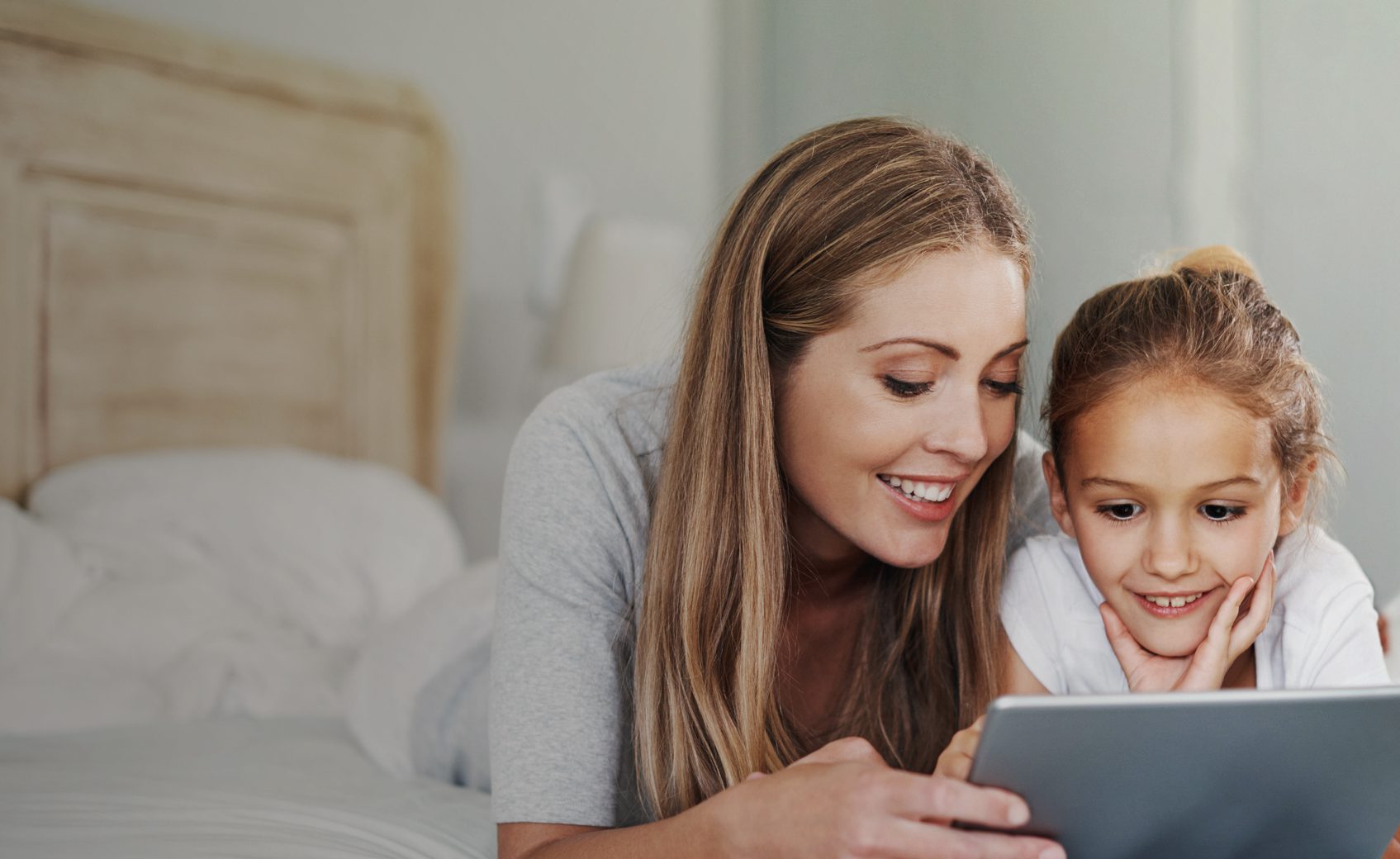 Shot of an adorable little girl and her beautiful mother using a tablet at home